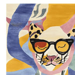 A vibrant hand-tufted area rug featuring an abstract design of a cat wearing glasses. The rug showcases bold colors like blue, yellow, and pink, adding a playful touch to any room decor.