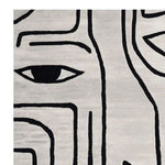 Close-up view of the Abstract Gaze Hand Tufted Area Rug, showcasing a modern black and white design with eye motifs. This contemporary wool rug is perfect for living room spaces, especially as an 8x10 centerpiece.