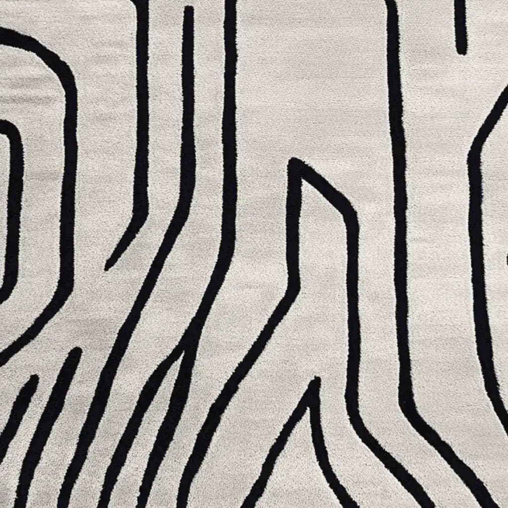 Top view of a contemporary rug showcasing an abstract design with bold black lines on a soft, cream wool surface. Perfect for enhancing living room spaces, this 8x10 area rug combines modern style with cozy comfort, ideal for those seeking stylish living room area rugs.