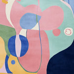 This vibrant abstract meadow dance hand-tufted area rug features a contemporary design with bold colors like pink, blue, green, and yellow. Perfect for adding a splash of modern style to your living room, this wool rug offers both texture and artistic flair.