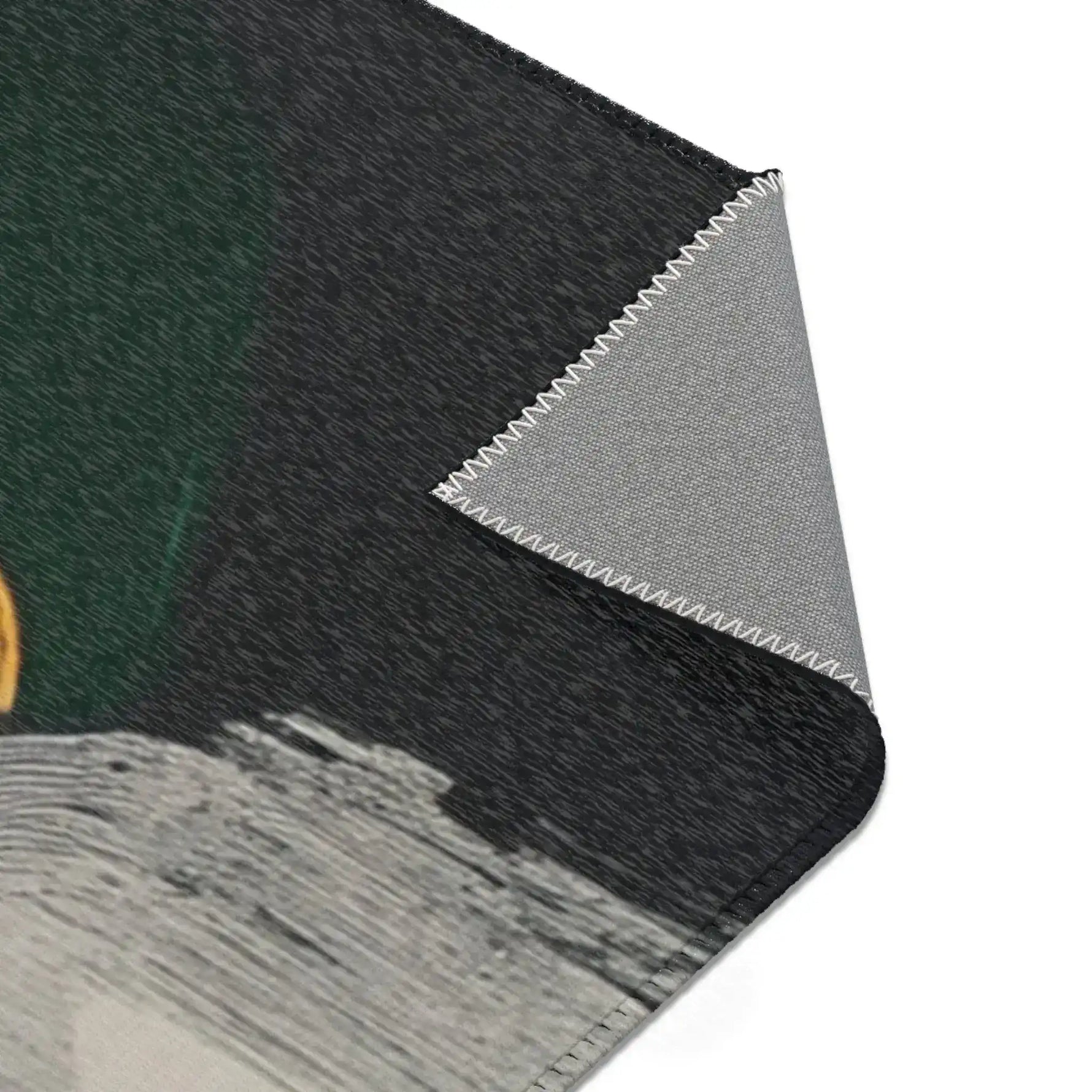 Abstract Noir Portrait Rug folded corner detail showing dark green-black face with slight gold accent, grey backing edge
