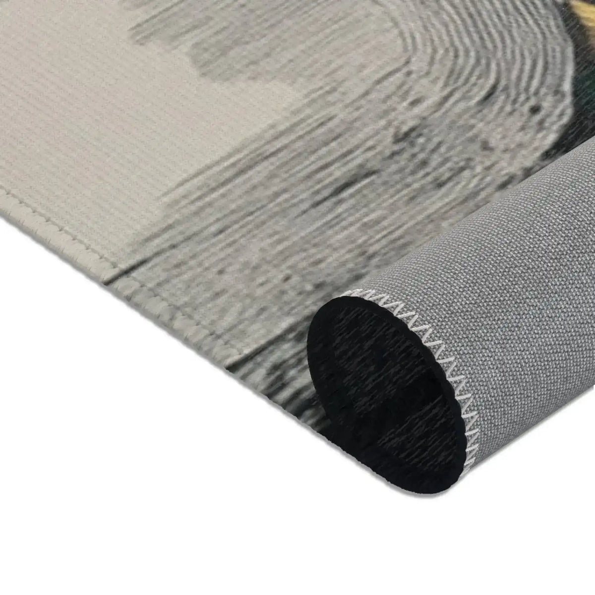 Abstract Noir Portrait Rug rolled corner view showing pale grey brushstroke area with dark tube curl, backing detail