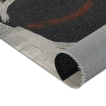 Abstract Noir Portrait Rug rolled edge close-up showing white-grey brushstroke border and red-brown arc detail, grey backing