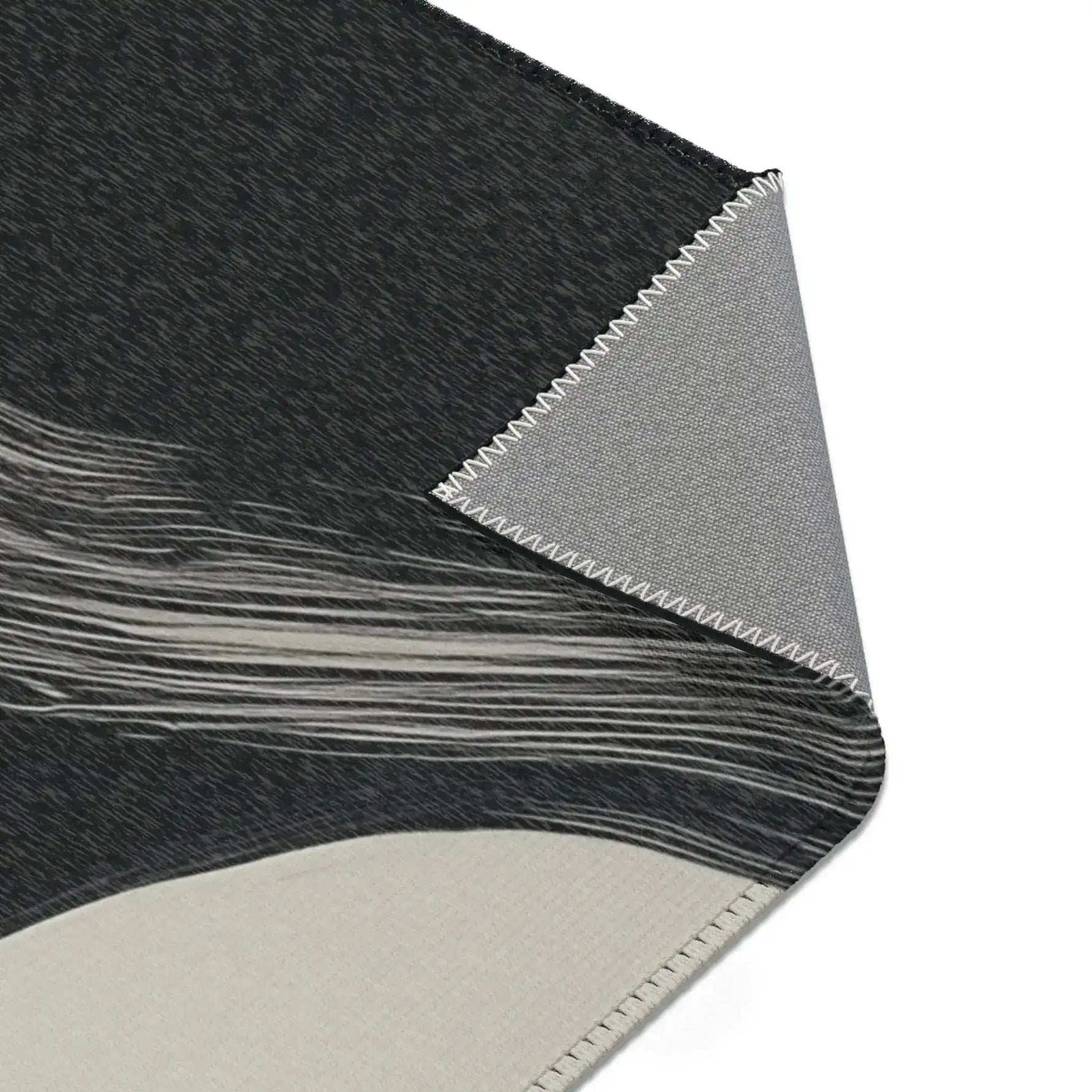 Abstract Noir Striped Elegance Rug wave stripe corner — charcoal pile with sweeping white horizontal lines near edge, backing fold shown