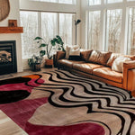 abstract odyssey hand tufted viscose rug in a light-filled room with floor-to-ceiling windows, leather sofa and fireplace