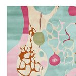 A vibrant area rug with an abstract design featuring bold colors like teal, pink, and brown, perfect for adding a contemporary touch to your living room. This hand-tufted wool rug showcases an artistic pattern with organic shapes, making it a standout piece among area rugs for living room decor.