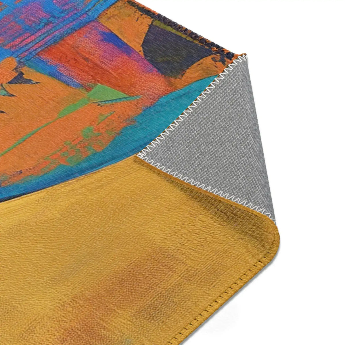 Corner detail of Abstract Silhouette Rug folded showing rich crimson and gold ornate scrollwork pattern on textile face, grey backing at edge