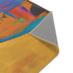 Corner detail of Abstract Silhouette Rug folded showing rich crimson and gold ornate scrollwork pattern on textile face, grey backing at edge