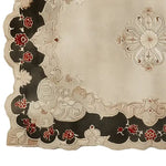 A detailed view of an antique splendor hand-tufted wool area rug featuring intricate floral patterns with bold red and black accents on a cream background.