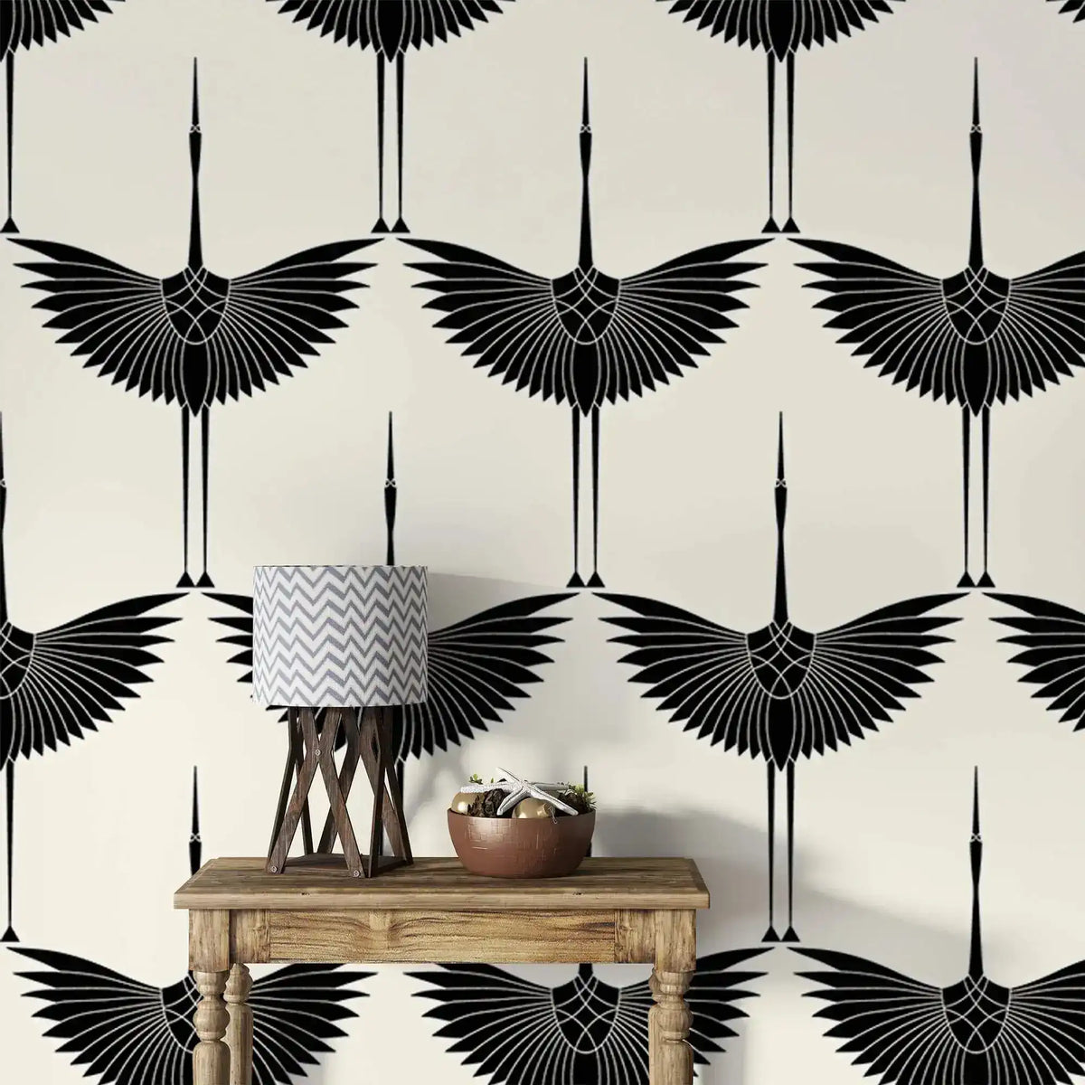 Art Deco Black Heron crane wallpaper, wings outstretched on ivory, behind a wood console and lamp