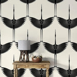 Art Deco Black Heron crane wallpaper, wings outstretched on ivory, behind a wood console and lamp