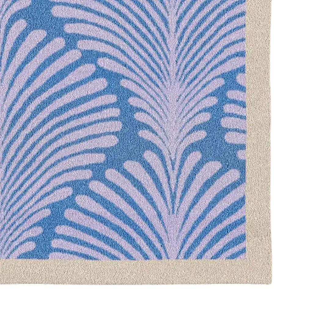 This image showcases a corner detail of the Art Deco Scallop Blue Hand Tufted Wool Rug, an elegant area rug perfect for enhancing office spaces or large living rooms. The rug features a striking blue background with an intricate scallop pattern, embodying a sophisticated art deco style.
