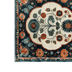 A close-up view of the Artesian Splendor Knotted Wool Rug, featuring intricate floral patterns in vibrant orange, teal, and cream colors. This elegant area rug is perfect for adding a touch of luxury to living room area rugs, crafted from high-quality wool for a soft and durable finish.