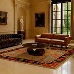 Artisan Floral Masterpiece rug in a grand classical salon under dark leather sofas; grey-blue field with red floral border and black edging