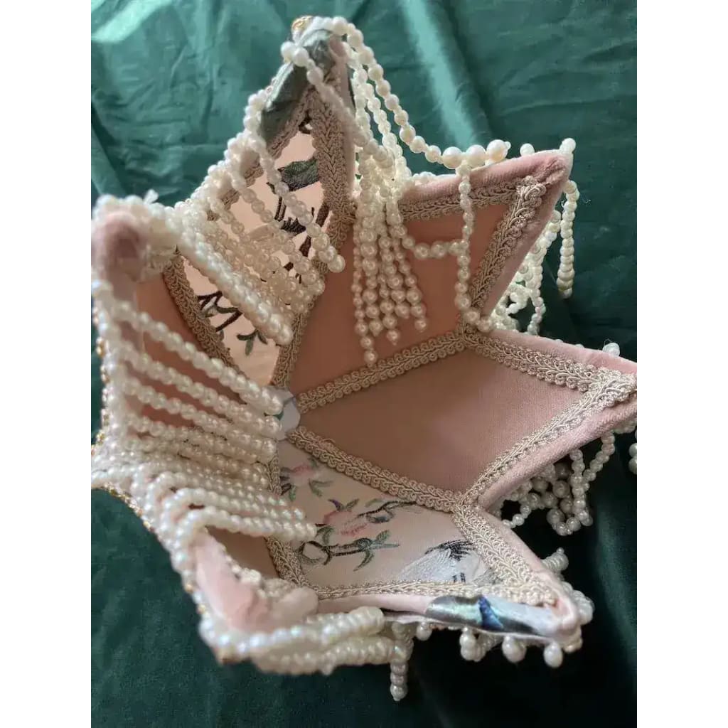 Interior view inside the jacquard lamp shade — pink fabric panels with floral embroidery, pearl bead fringe, gold trim