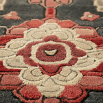 Close-up of a floral patterned rug with red and gray colors.