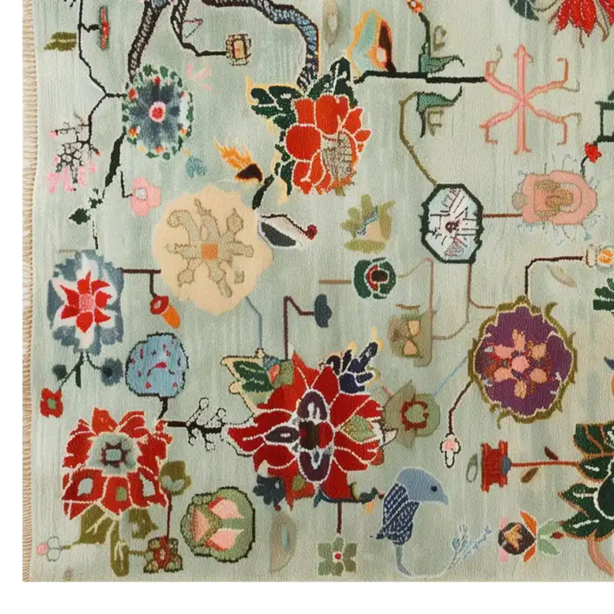 A vibrant Avant Bloom Knotted Wool Area Rug featuring an intricate array of colorful floral patterns and abstract designs on a light background. The rug showcases red, blue, and green hues in a harmonious blend, adding a touch of elegance and artistic flair to any room.