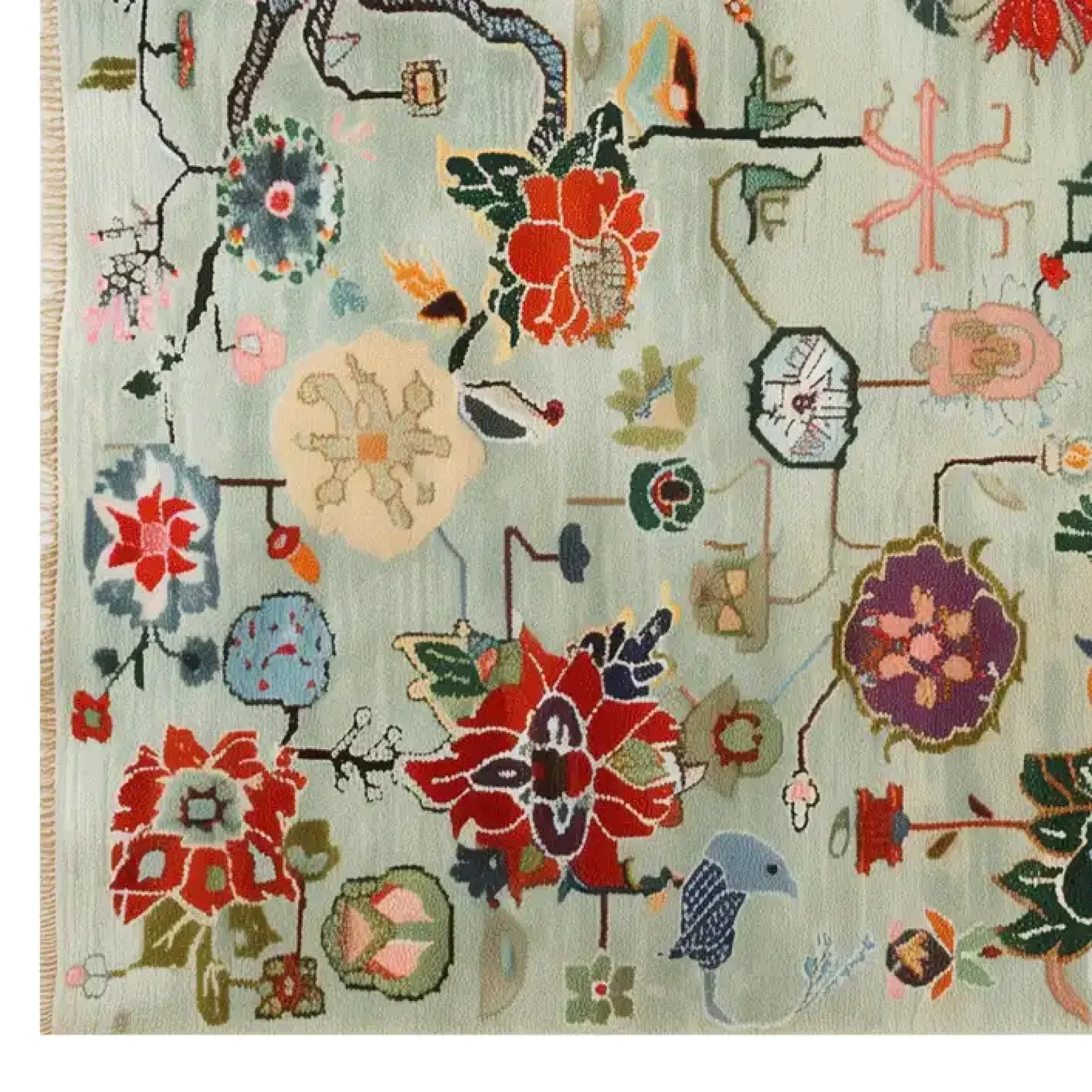 A vibrant Avant Bloom Knotted Wool Area Rug featuring an intricate array of colorful floral patterns and abstract designs on a light background. The rug showcases red, blue, and green hues in a harmonious blend, adding a touch of elegance and artistic flair to any room.