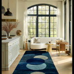 Navy wool runner with cream and blue orbs in a sunlit kitchen-lounge with an arched window and curved sofa