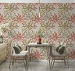 Banana grove wallpaper in pink and green behind a wood dining table with chairs and pendant light