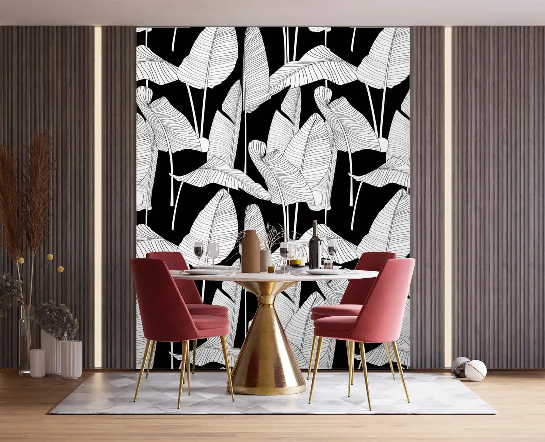 Oversized banana leaf wallpaper with white line-art leaves on black, installed behind dining table with pink chairs