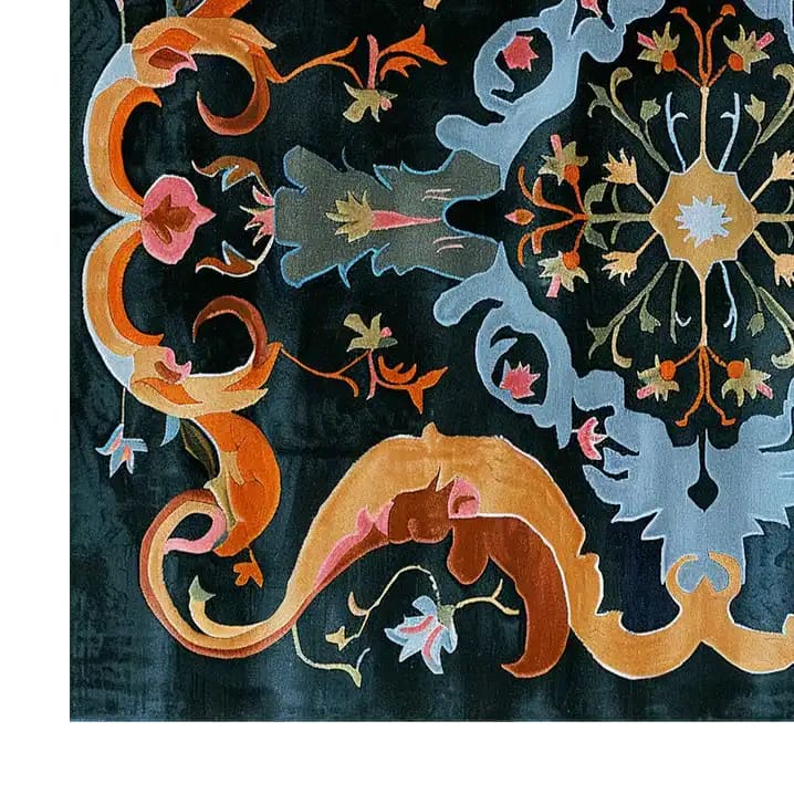 A vibrant and intricately designed area rug featuring bold baroque patterns with swirling orange, pink, blue, and gold motifs on a dark background, showcasing the craftsmanship and elegance of hand-tufted wool.
