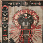 A richly detailed hand-knotted area rug titled 'Beneath the Pyramids' featuring a striking Egyptian-inspired design with intricate patterns and earthy colors. The central motif includes a stylized figure with sunburst elements, surrounded by geometric and symbolic borders, showcasing exquisite craftsmanship.