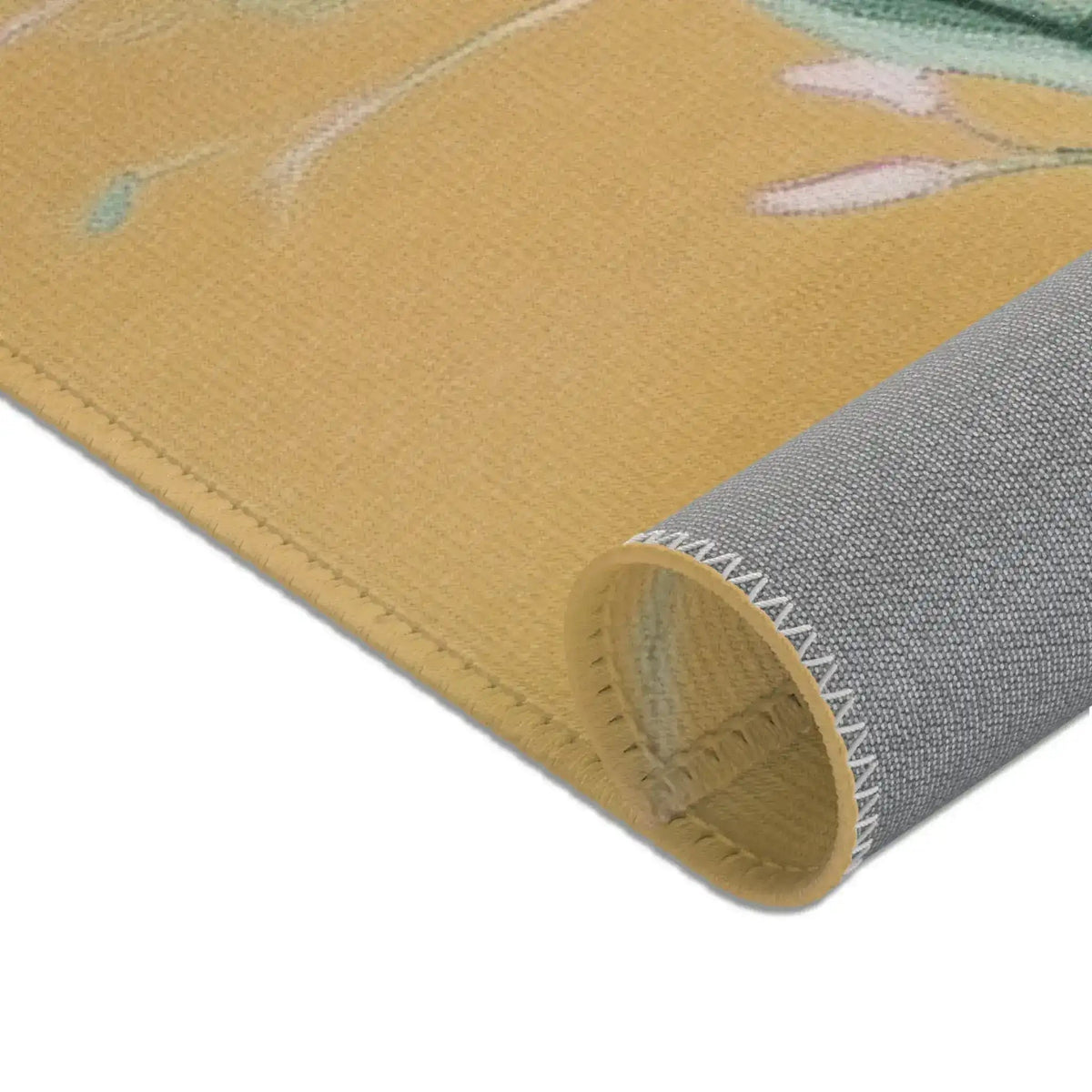 Rolled corner of Birds and Blossoms Accent Rug revealing grey non-slip backing and stitched hem, golden floral face visible