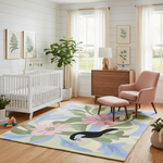 Nursery room with a crib, green nature inspired rug, and furniture