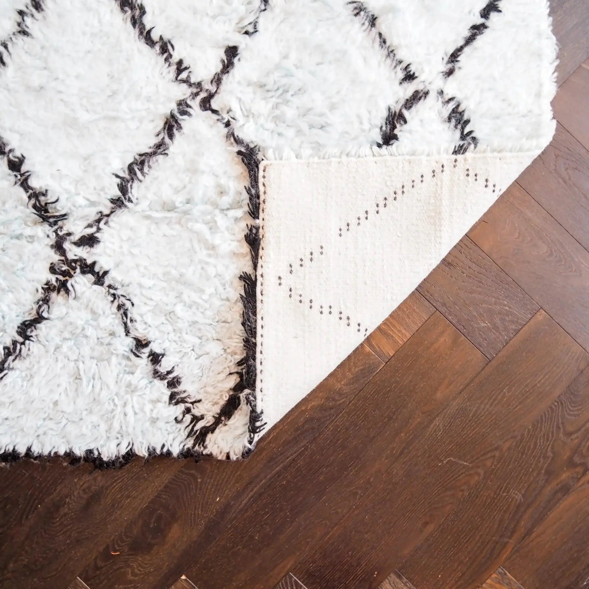 A luxurious Black and Blue Diamonds Shag Wool Rug displayed in a living room setting. This elegant area rug features a plush, textured surface with a chic black diamond pattern on a soft blue background. Perfect for enhancing the ambiance of any living room, this wool rug adds warmth and style to your space. Ideal for those seeking living room area rugs that combine comfort and modern design.