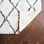A luxurious Black and Blue Diamonds Shag Wool Rug displayed in a living room setting. This elegant area rug features a plush, textured surface with a chic black diamond pattern on a soft blue background. Perfect for enhancing the ambiance of any living room, this wool rug adds warmth and style to your space. Ideal for those seeking living room area rugs that combine comfort and modern design.