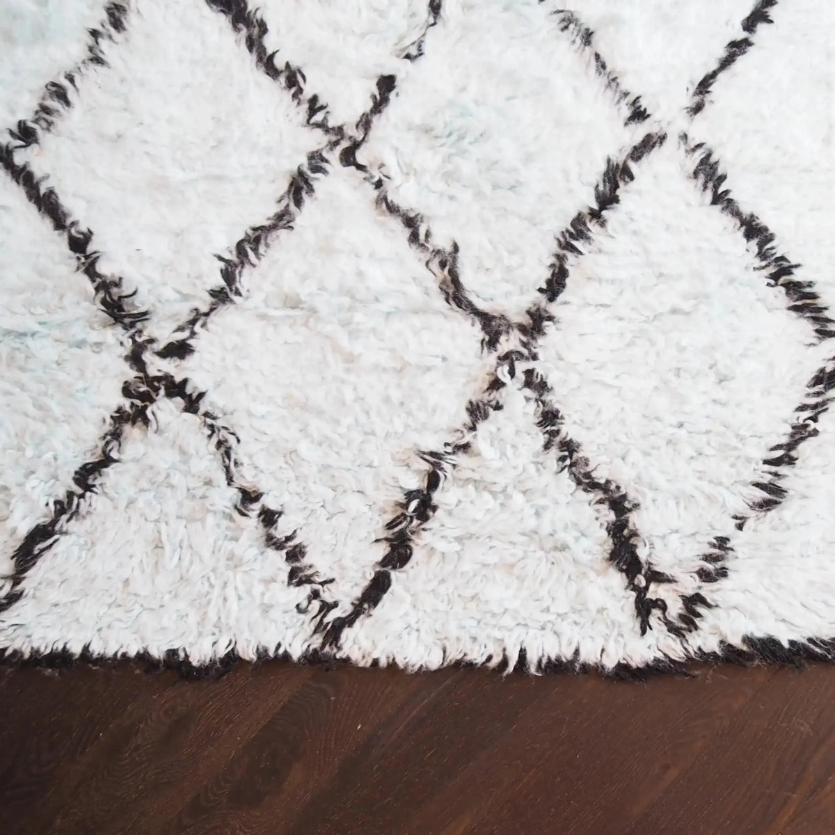 A cozy Black and Blue Diamonds Shag Wool Rug, showcasing a plush and textured surface with a diamond pattern. Perfect for adding warmth and style to a living room, this area rug complements modern and contemporary interiors. Ideal for those seeking quality wool rugs for living room spaces.