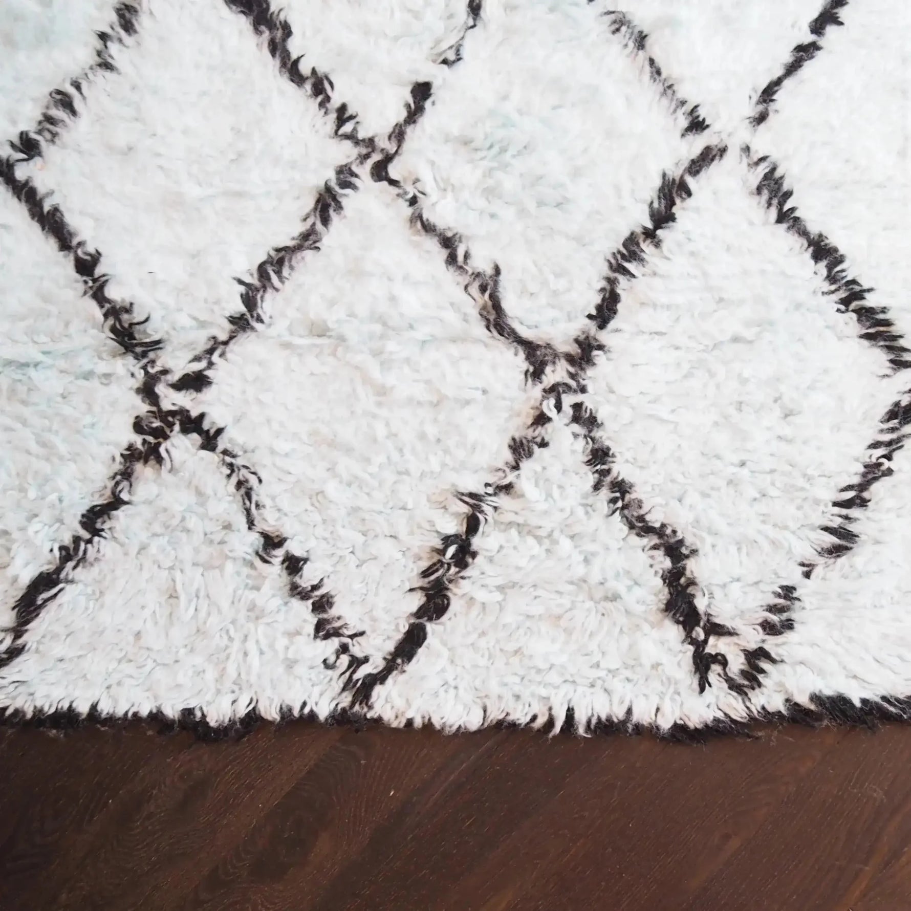 A cozy Black and Blue Diamonds Shag Wool Rug, showcasing a plush and textured surface with a diamond pattern. Perfect for adding warmth and style to a living room, this area rug complements modern and contemporary interiors. Ideal for those seeking quality wool rugs for living room spaces.
