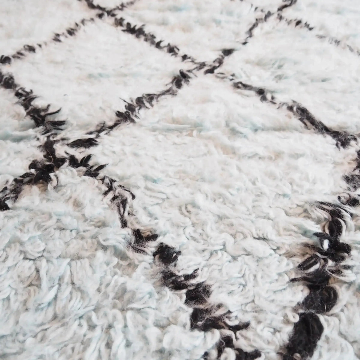 Close-up of a Black and Blue Diamonds Shag Wool Rug, showcasing its intricate diamond pattern and luxurious texture. Perfect for adding a cozy touch to your living room area. Ideal for those seeking stylish living room area rugs and quality wool rugs.