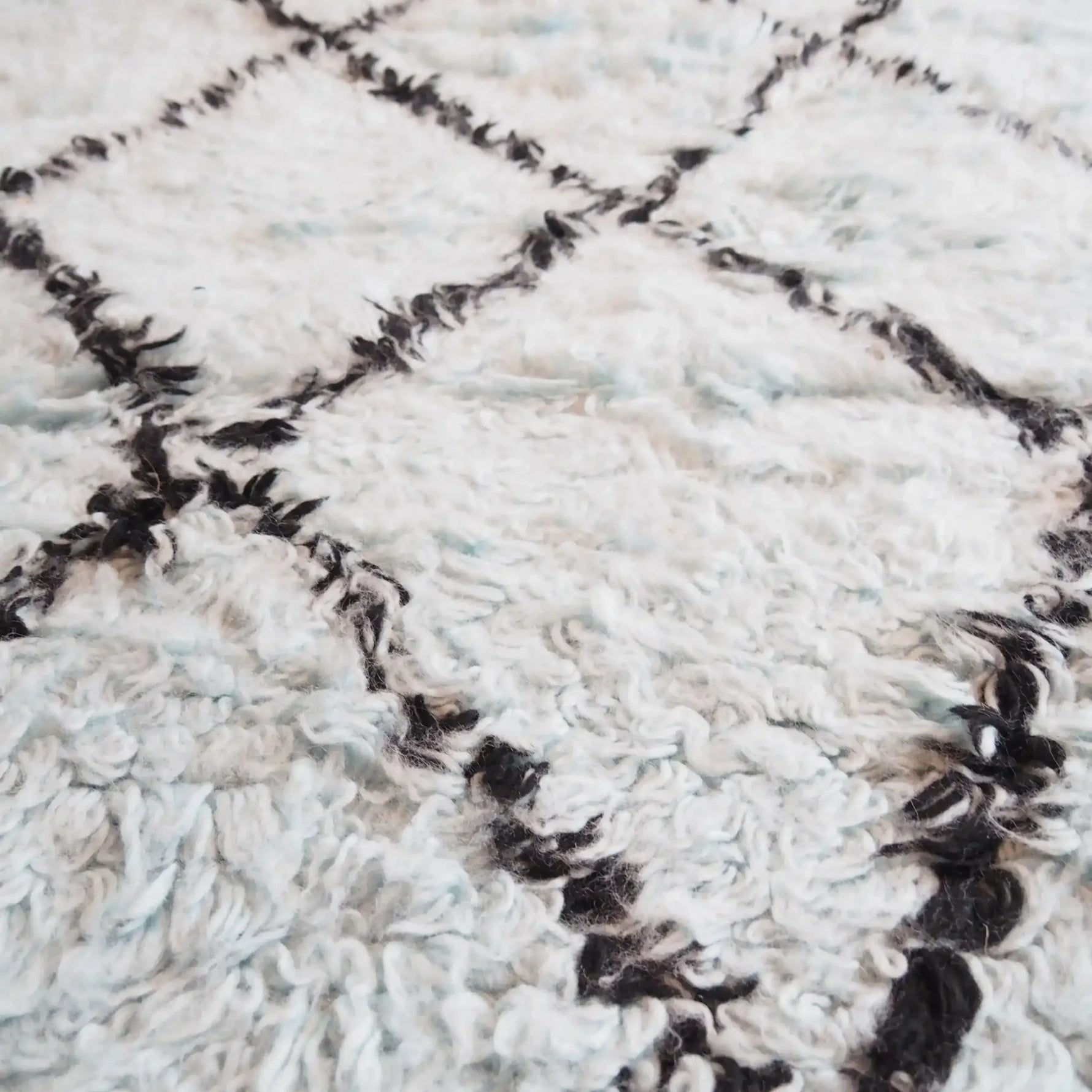 Close-up of a Black and Blue Diamonds Shag Wool Rug, showcasing its intricate diamond pattern and luxurious texture. Perfect for adding a cozy touch to your living room area. Ideal for those seeking stylish living room area rugs and quality wool rugs.