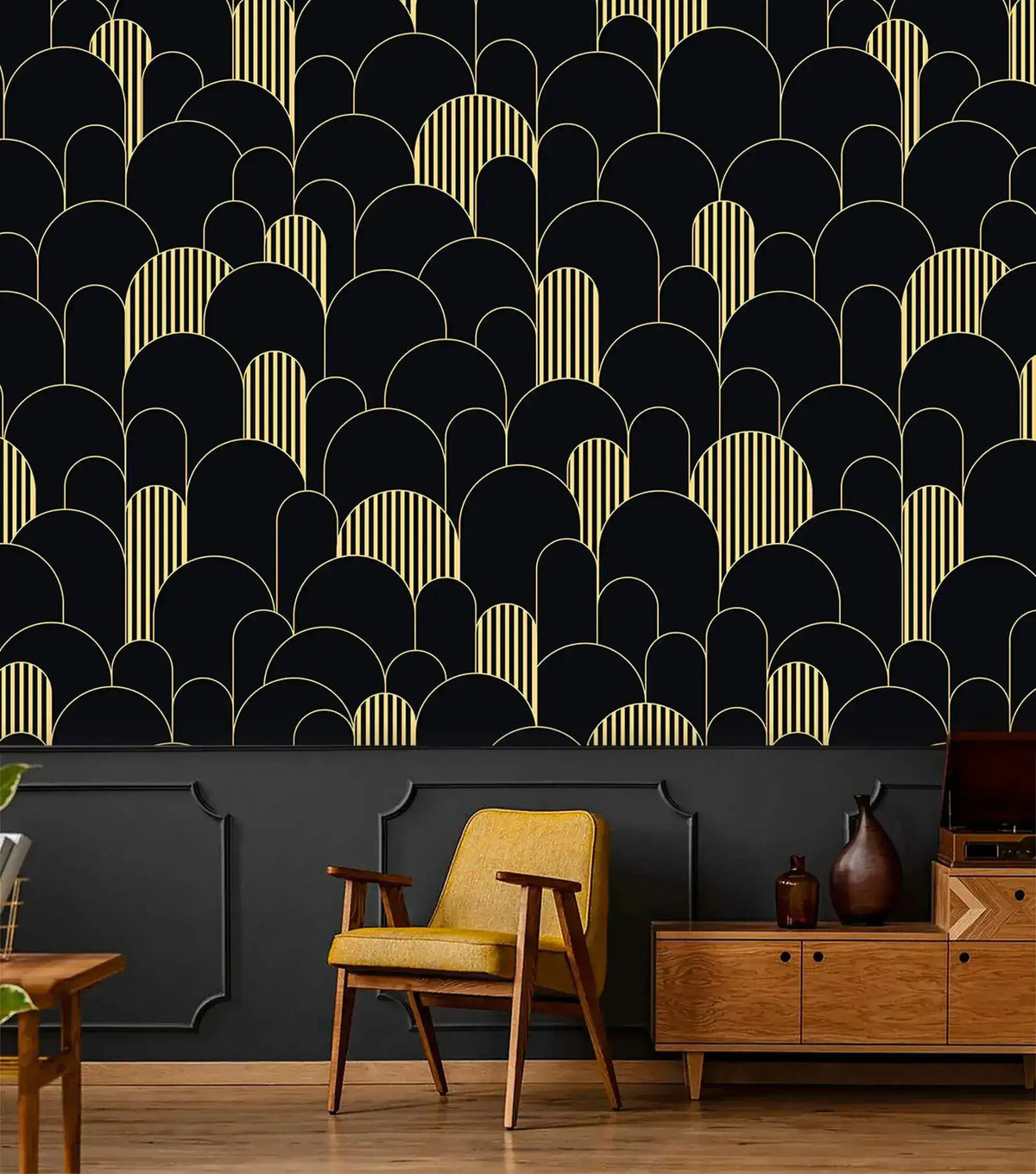 Black and gold art deco arch wallpaper above dark wainscoting with mustard chair and wood credenza