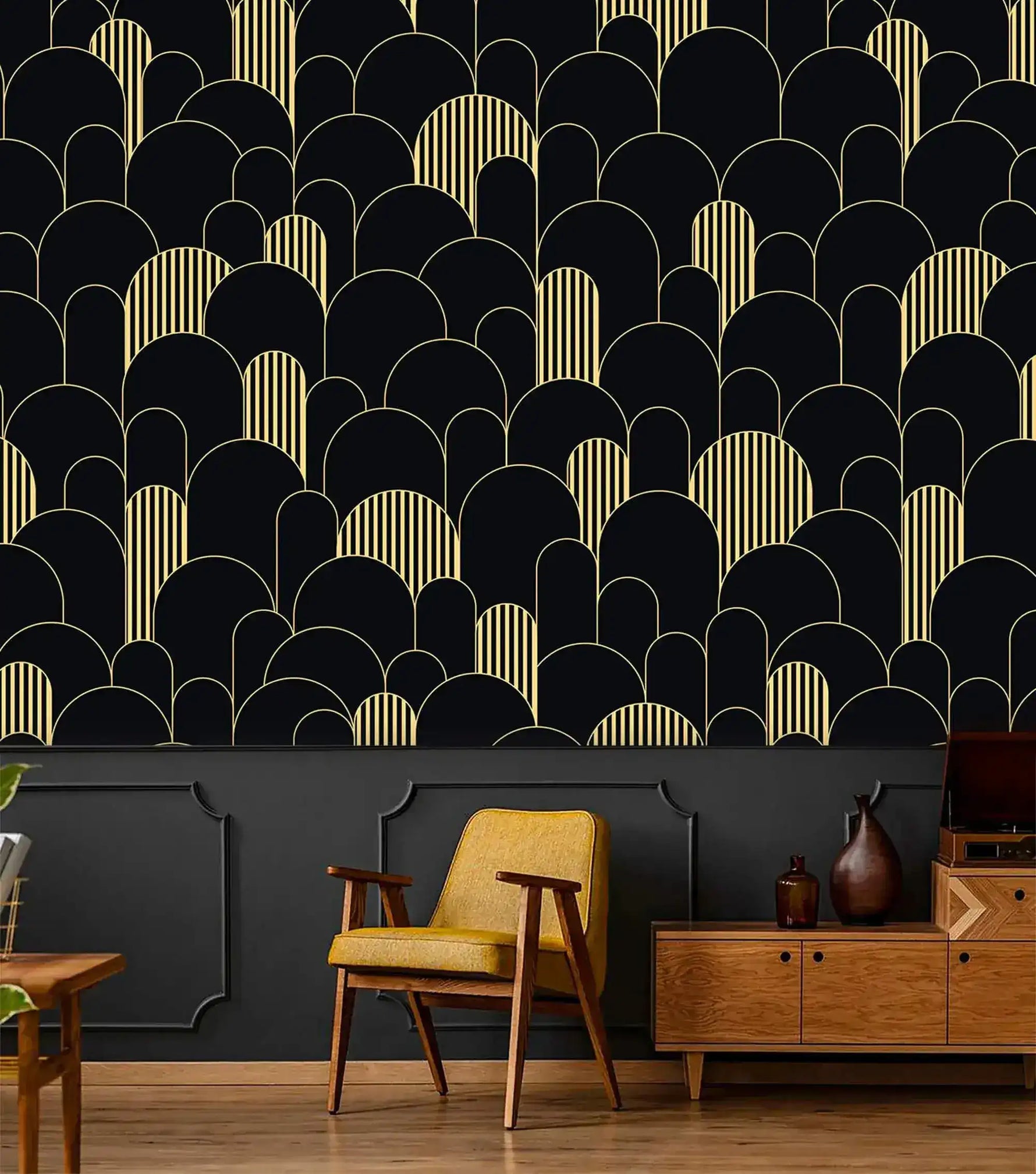 Black and gold art deco arch wallpaper above dark wainscoting with mustard chair and wood credenza