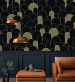 Black and gold art deco arch wallpaper above navy wainscoting with copper pendants and tan leather seating