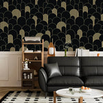 Black and gold art deco arch wallpaper above wainscoting with a black leather sofa and shelf unit