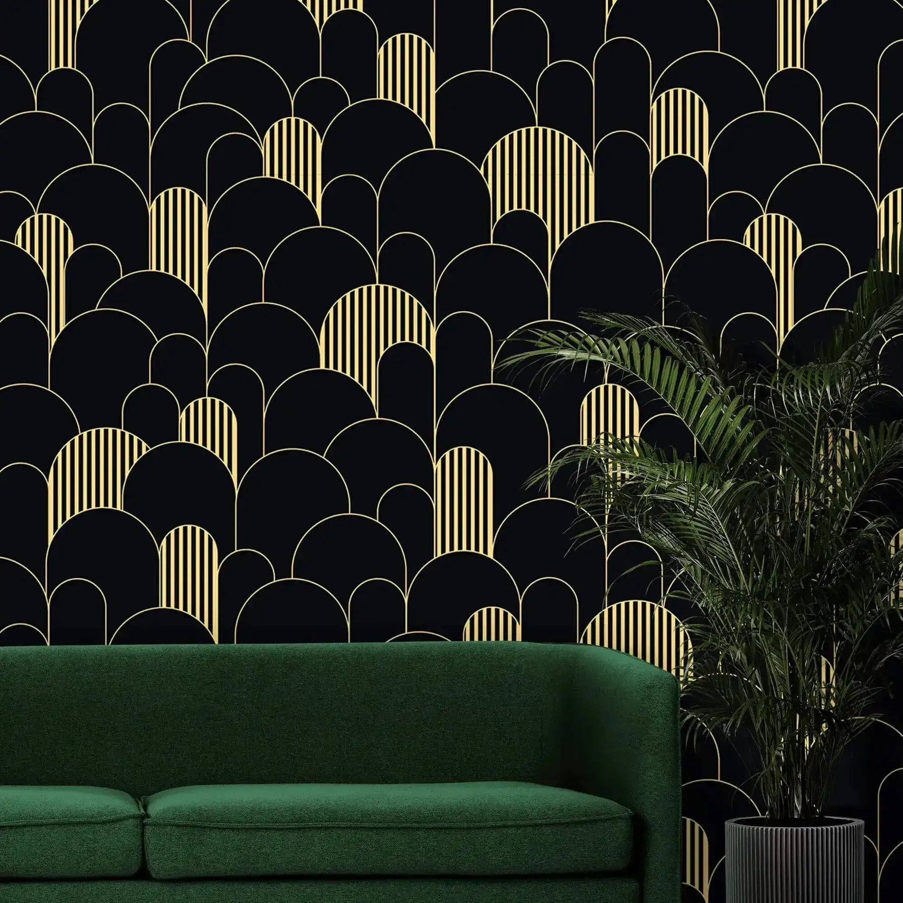 Black and gold art deco arch wallpaper behind an emerald sofa with a potted palm