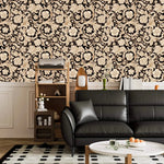 Black and gold damask floral wallpaper above white panelling with black leather sofa and shelf