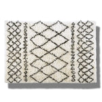 Top view of a Black and White Diamonds Shaggy Wool Area Rug, perfect as a runner rug for bathrooms, kitchens, or hallways. The rug features a striking black geometric diamond pattern on a white shaggy wool texture, adding a touch of elegance to any space.