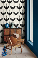Black Heron crane silhouette wallpaper beside a navy wall with antique cabinet and chair