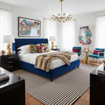 Modern bedroom with a blue bed, colorful artwork, and striped rug.
