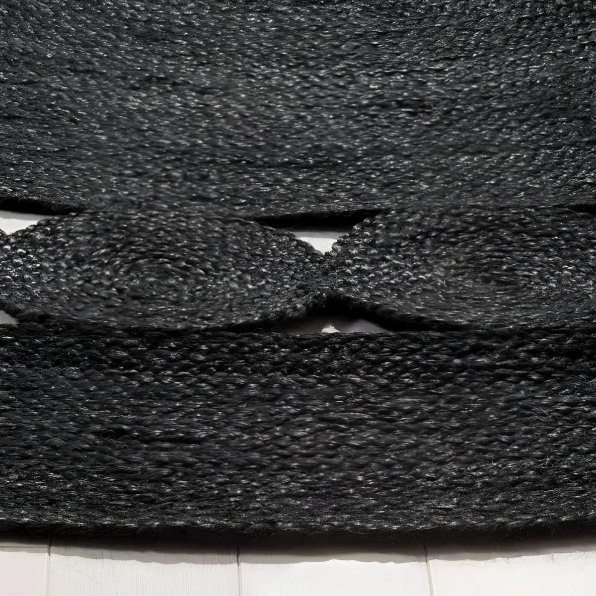 Close-up view of a black round jute area rug, showcasing its intricate woven texture. Perfect for adding a natural touch to any office or living room, this large area rug combines durability with style.