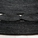 Close-up view of a black round jute area rug, showcasing its intricate woven texture. Perfect for adding a natural touch to any office or living room, this large area rug combines durability with style.