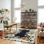 Modern office room with a floral rug, bookshelf, and artwork.