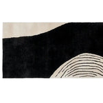 This image features a contemporary wool runner rug with a striking abstract design, perfect for enhancing any hallway. The rug showcases bold black and white patterns with curved lines, making it an ideal choice for a kitchen or bathroom runner rug.