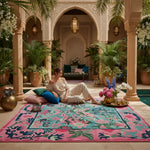 Woman sitting on a colorful rug in a decorative indoor setting with plants and flowers.