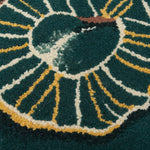 Close-up of a rug, circular design with concentric circles on a dark green background.